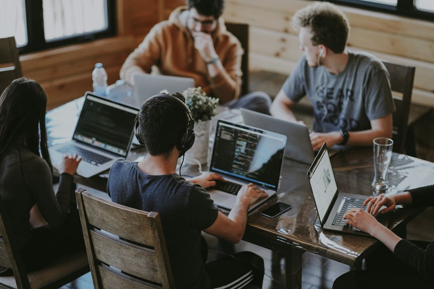 A small team working together on laptops around a shared table